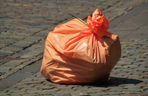 orange trash bag to be thrown into a rented dumpster