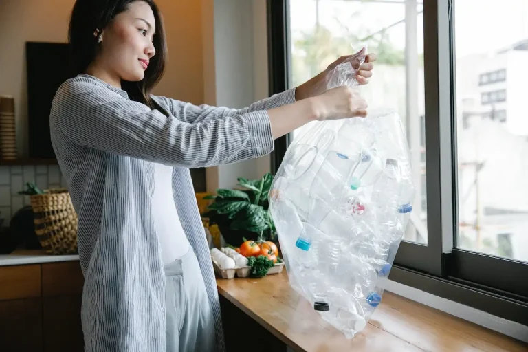 Woman recycling plastic bottles after learning how to dispose of household items
