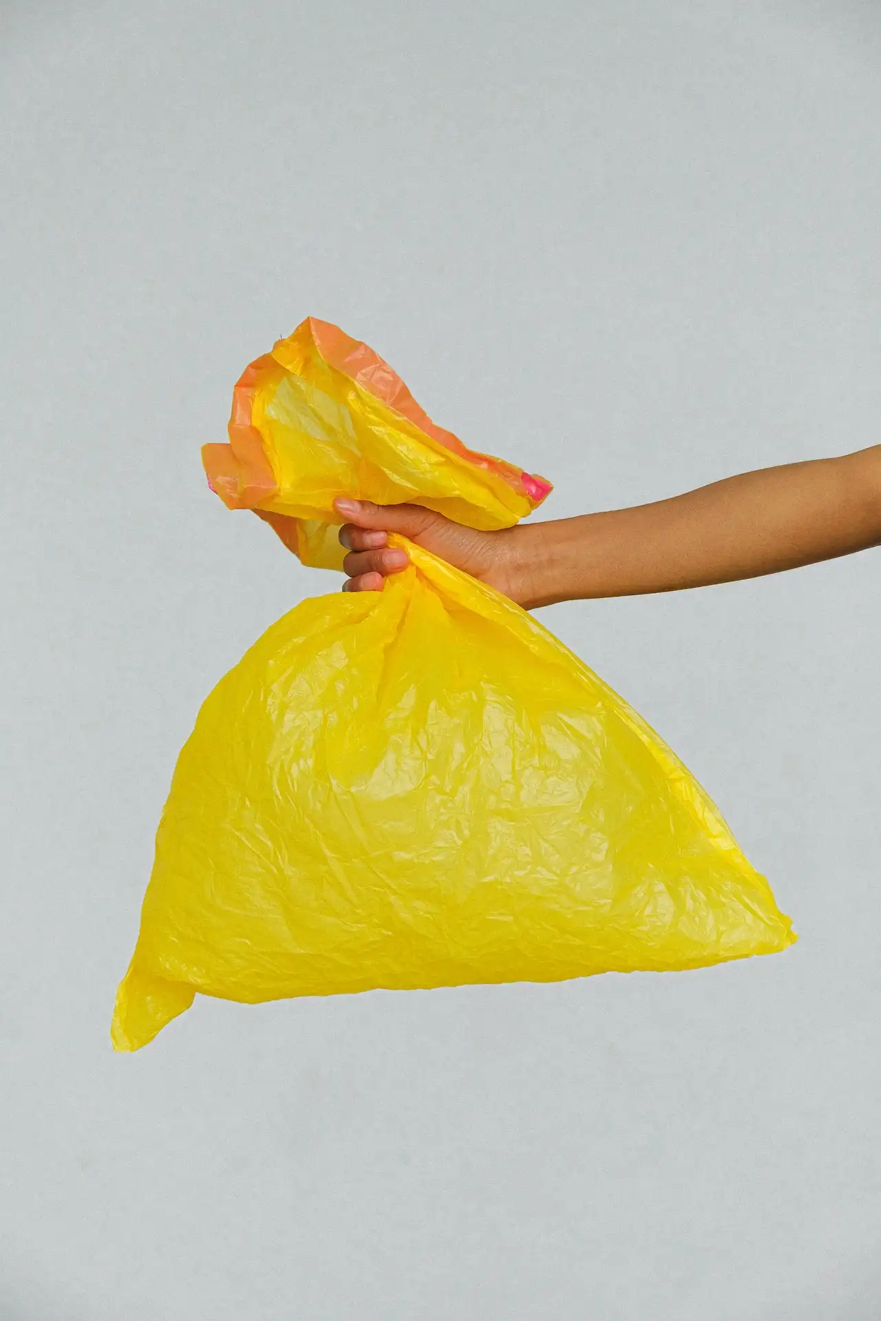 Picture of a person holding a garbage bag taking it to the dump in Madison, North Carolina.